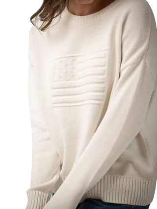 Close-up of a person wearing a beige sweater on a plain background