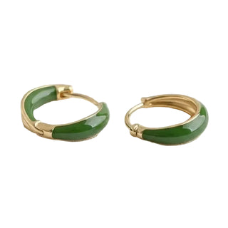 Green hoop earrings with gold accents on a light gray background