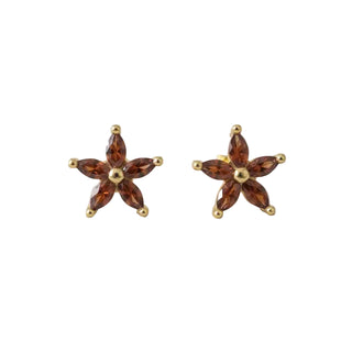 Pair of Chanel earrings with white pearls and gold accents on a white background